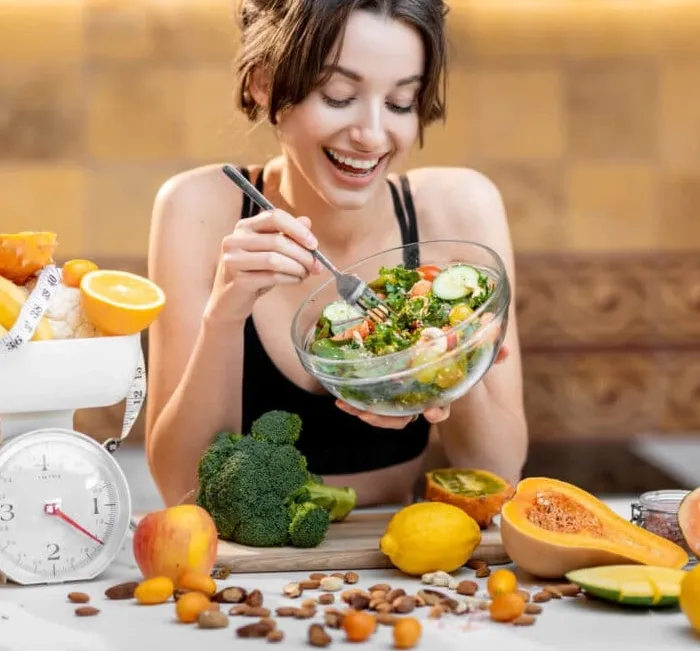 Woman eating a healthy salad as part of a weight management routine